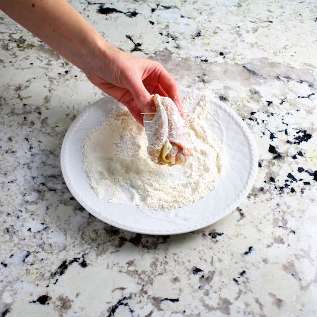 Dredging uncooked chicken in flour