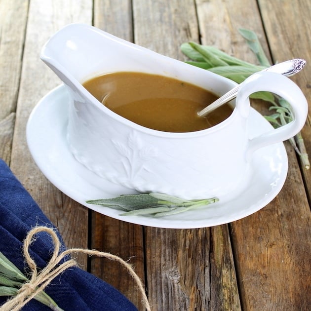 White Wine Turkey Gravy in a white gravy boat with sage