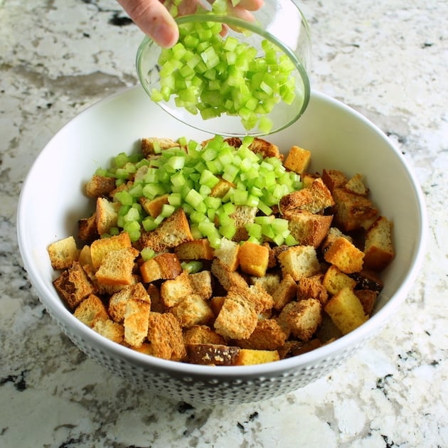 Adding celery to mixing bowl for turkey stuffing