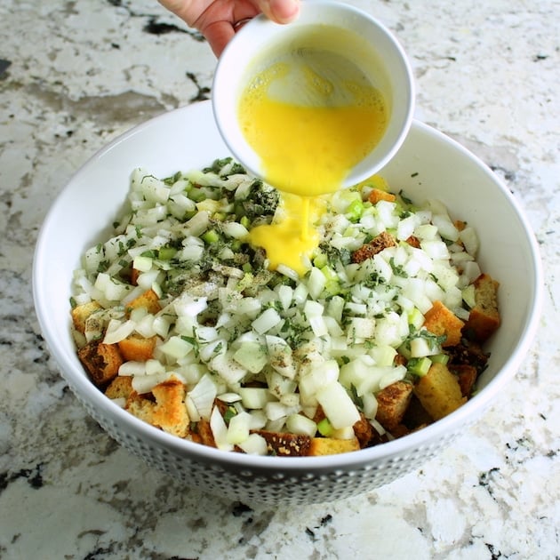 Adding egg to mixing bowl for turkey stuffing