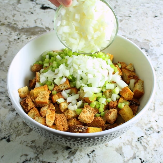 Adding onion to mixing bowl for turkey stuffing