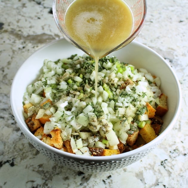 Adding turkey drippings to mixing bowl for turkey stuffing