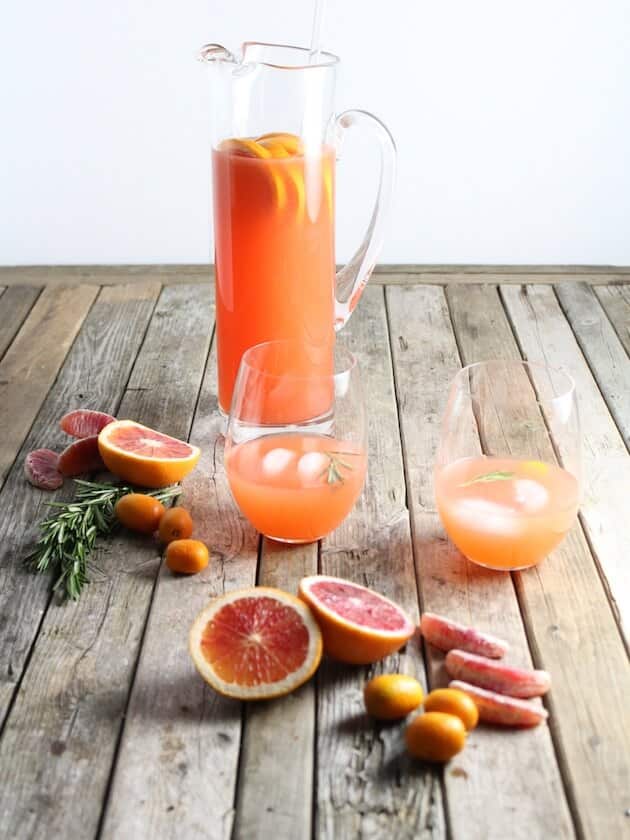 Aperol Punch in tall glass picther with grapefruit on table