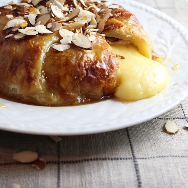 Baked Brie in Puff Pastry with cheese oozing out 