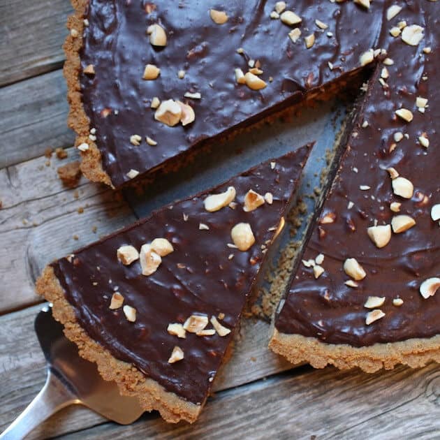 Chocolate Hazelnut Tart with slice being removed on spatula