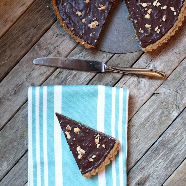 slice of Chocolate Hazelnut Tart on blue cloth 