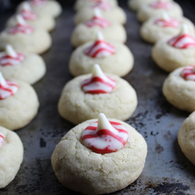 Thumbprint Cookies with peppermint Hershey Kiss centers on baking sheet.