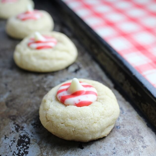 Two Thumbprint Sugar Cookies with peppermint centers on baking sheet