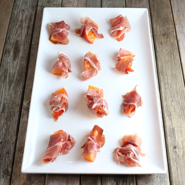 Prosciutto-wrapped persimmon slices on rectangle serving platter 