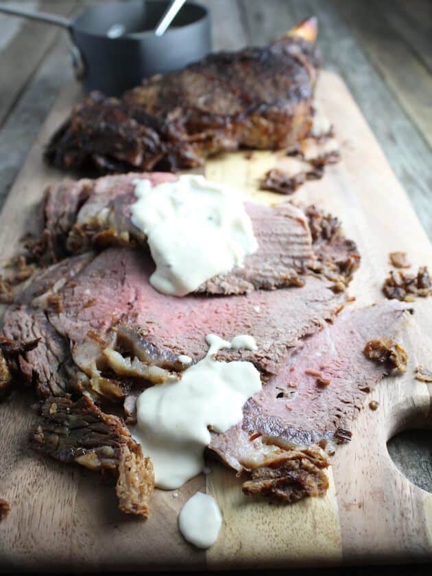 Sliced Standing Rib Roast on Cutting Board with Horseradish Sauce