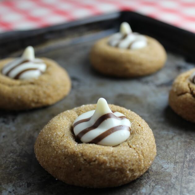 White Chocolate Kissed Gingerbread Thumbprint Cookies grouped on a cookie sheet