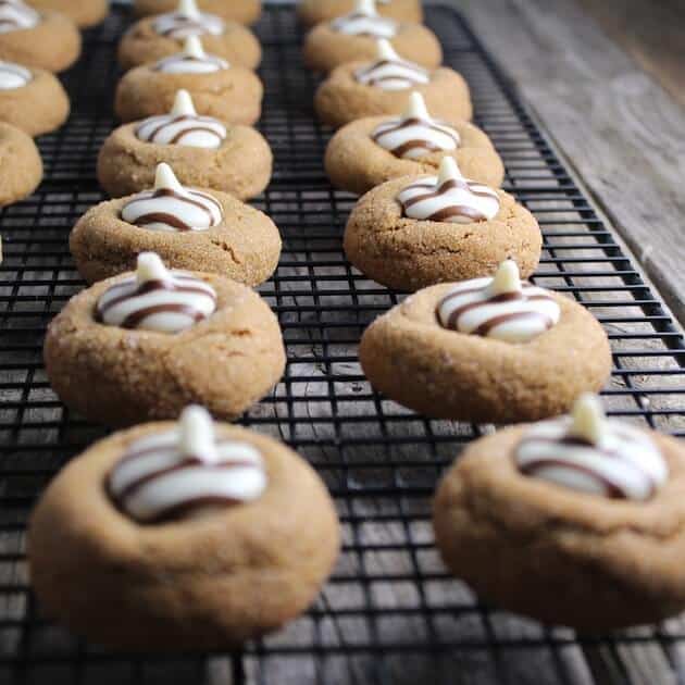 White Chocolate Kissed Gingerbread Thumprint Cookies on a wire cooking rack 