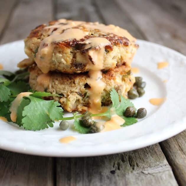 Two Tuna Cakes stacked on plate, With Aioli and capers