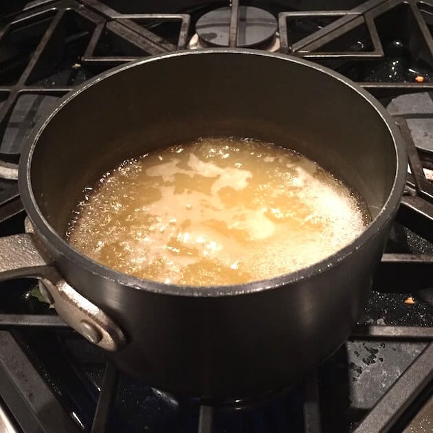 chicken stock boiling on stove in saucepan