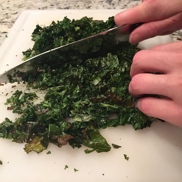 Chopping baked kale on cutting board