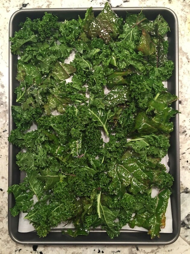 Oiled kale on baking sheet ready to cook