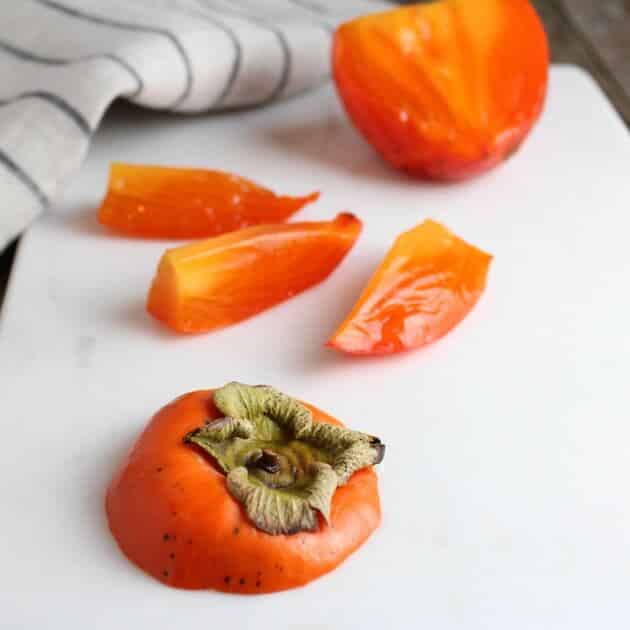 Persimmon sliced on cutting board