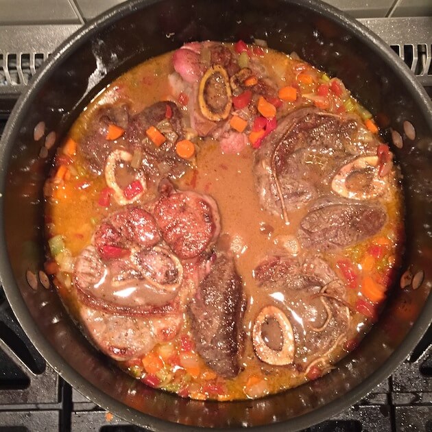 Veal Osso Buco in Dutch Oven covered in sauce, ready to cook
