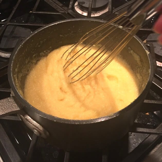 Whisking Polenta in saucepan while cooking