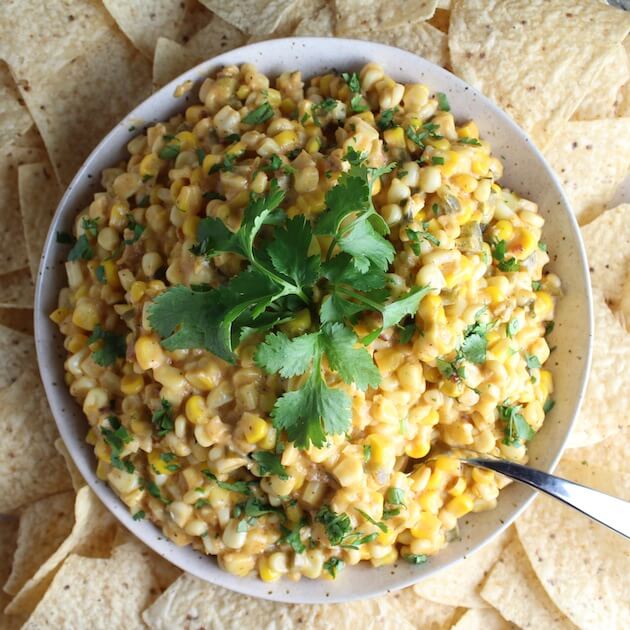 Creamy Cheesy Corn Dip in large white serving bowl with chips