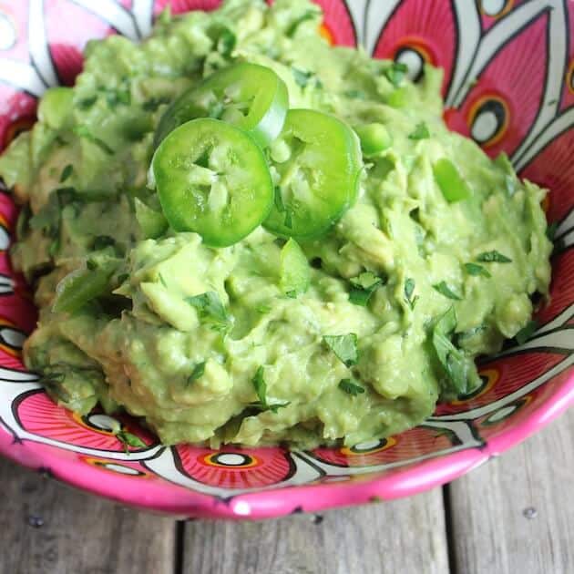 Guacamole with sliced jalapenos in a bowl