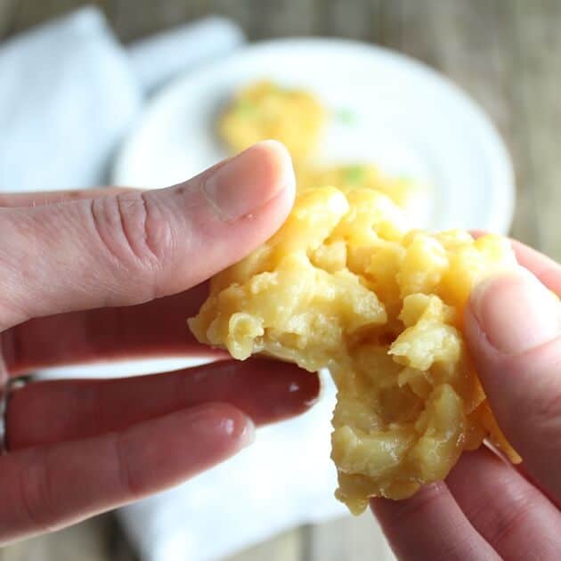 hands pulling apart a mac and cheese appetizer 