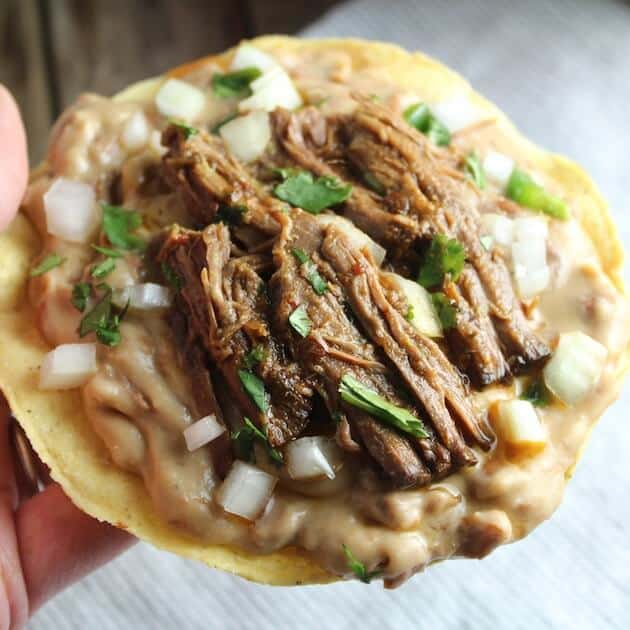 Crunchy Tostata with refried beans and beef barbacoa 