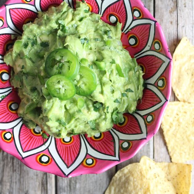 Guacamole in a mexican pottery bowl with corn chips