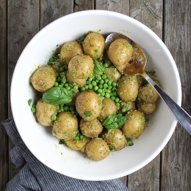 White serving bowl with potatoes, peas, &amp; basil 