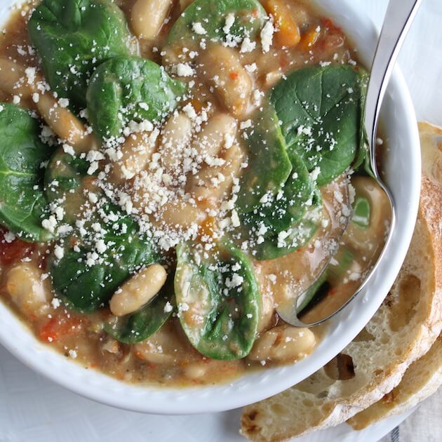 Close up of Spicy Italian White Bean and Sausage Soup with fresh spinach