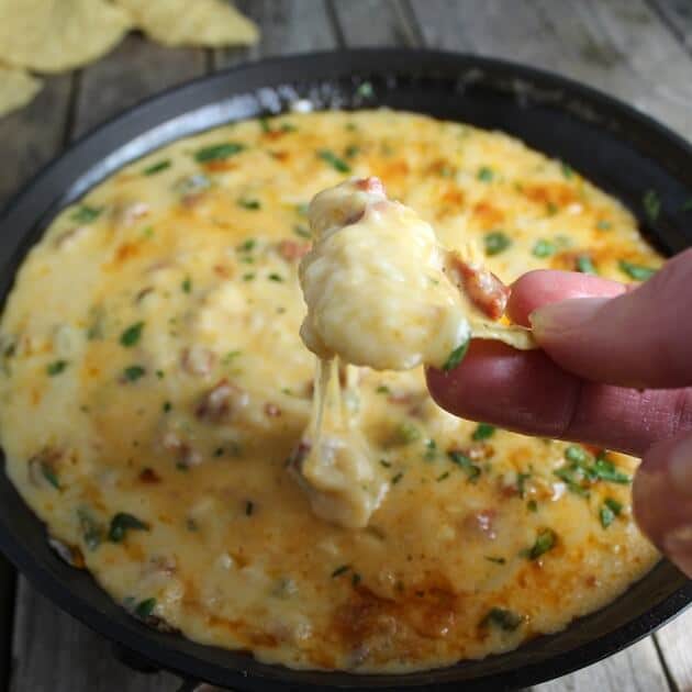 Corn chip dipped into Queso Fundido With Chorizo