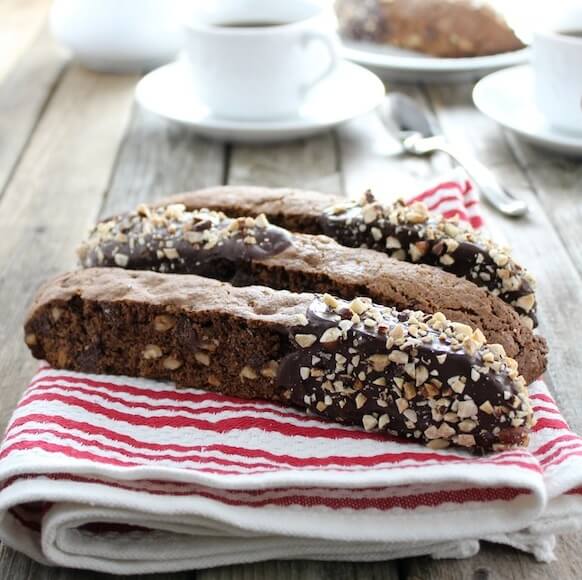 Chocolate dipped biscotti on a napkin with coffee