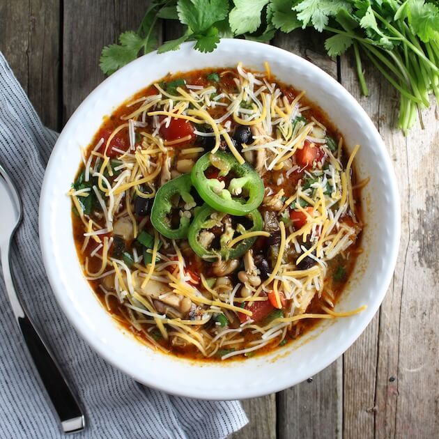 Bowl of Smoky Chicken Chili with shredded cheese &amp; jalapenos