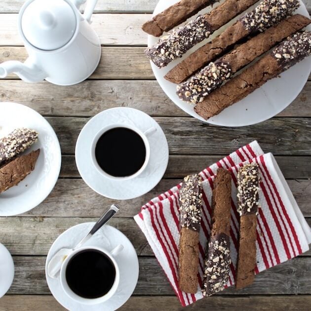 Table with multiple Chocolate Coffee Hazelnut Biscotti and cups of coffee