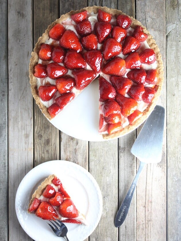 Slice of tart on a plate next to Strawberry Mascarpone on cake platter 