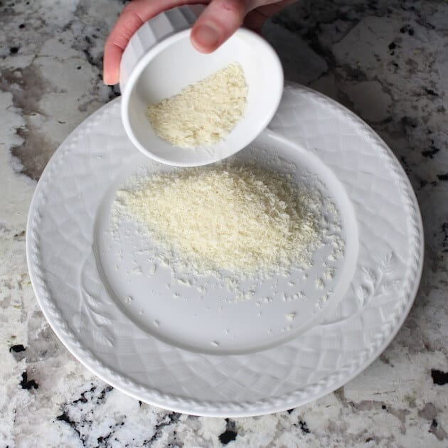 Adding parmesan to white plate