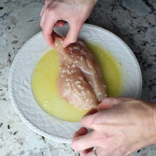 Coating chicken breast in lemon, garlic, butter 