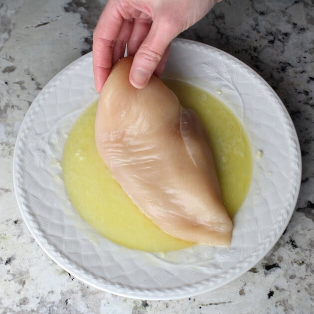 Coating chicken breast in lemon garlic butter mixture
