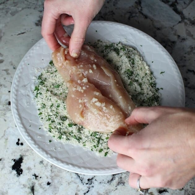 Coating chicken breast in bread crumb mixture