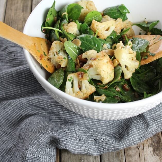 Partial bowl of spinach cauliflower salad