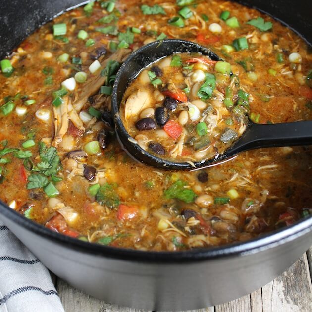 Smoky Chicken Chili in large cast iron soup pot with ladle 