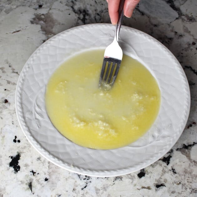 Mixing lemon, garlic, butter on a plate
