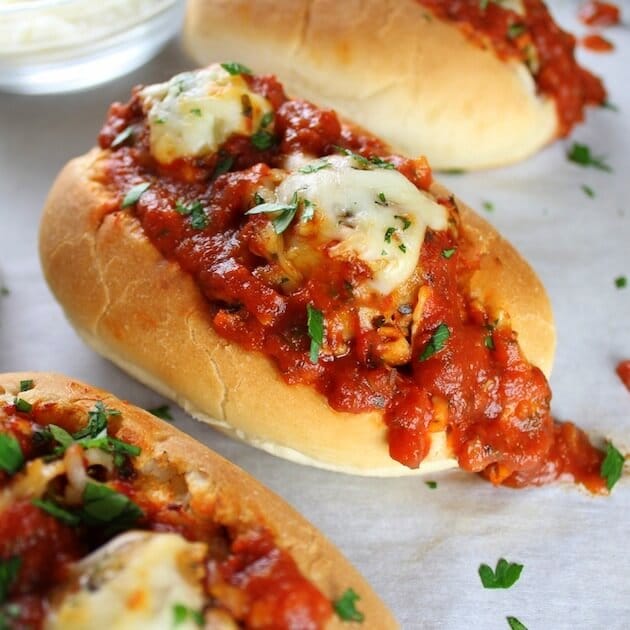 Three Italian Meatball Sub sandwiches on a plate.