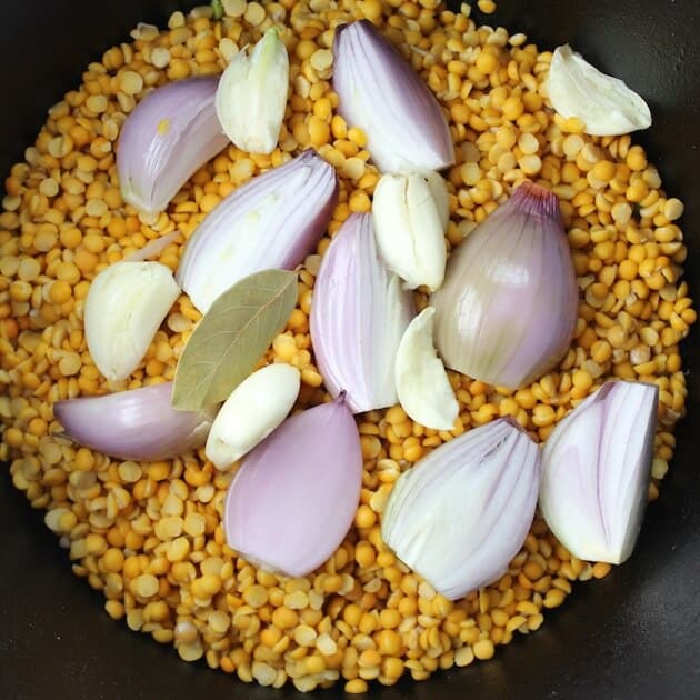 Red onion in pot with yellow peas