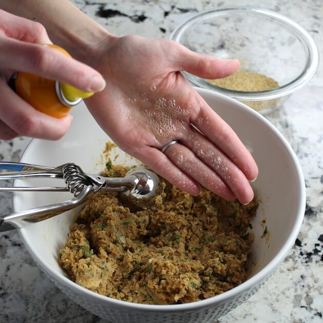 Spraying hands to prepare to roll meatballs