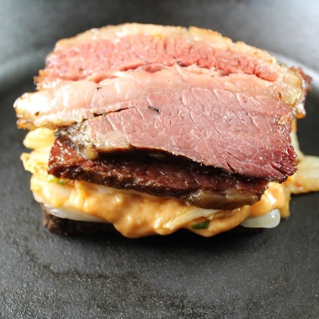 Adding corned beef to the sandwhich while cooking in a cast iron skilet.