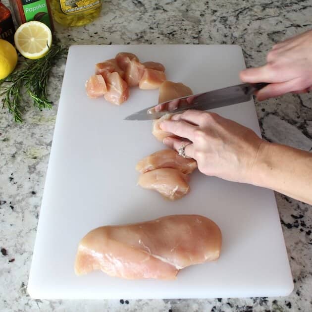 Cutting raw chicken on cutting board