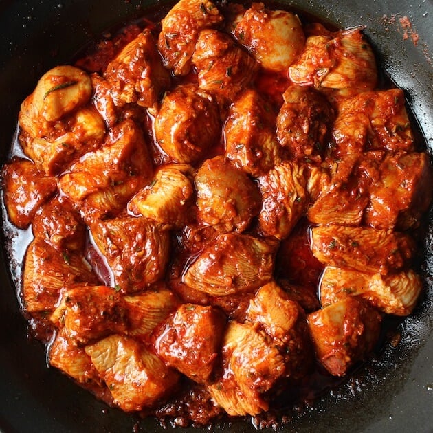The spicy Chicken Harissa Recipe cooking in a pan.