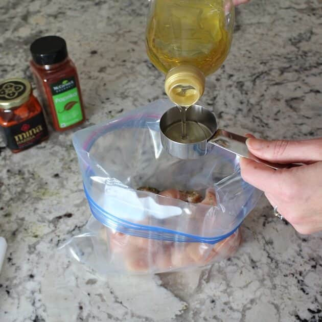 Adding olive oil to the marinade.