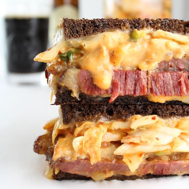 Close up of mouthwatering reuben sandwich oozing with thousand island and kimchi on pumpernickel 